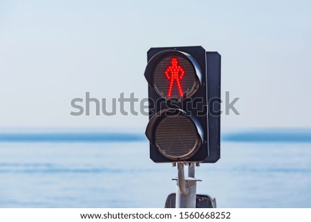 The red light of traffic light on the pedestrian railway crossing of a human silhouette.