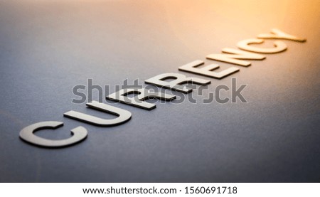 Word currency written with white solid letters on a board