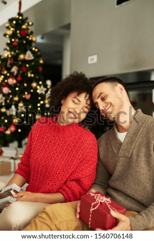Affectionate couple exchanging Christmas gifts