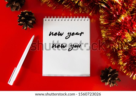 Notepad with goals and plans for the new year. Layout for design on the background of Christmas decor.