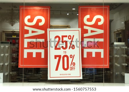 Sale up to 70% off text on a sign board inside a popular clothing store 