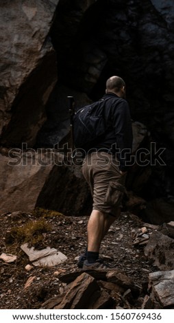 A hiker in the Lake District looking into a cave