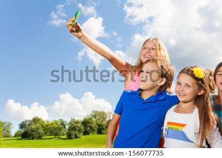 Group of kids kits taking a picture with camera phone