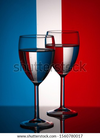 Two wine glasses silhouette full on french flag background. Alcohol beverage. French wine concept. Flag of France Royalty-Free Stock Photo #1560780017
