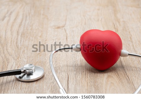 The red heart is plugged into the stethoscope.Placed on the table with a space to put text Heart health concepts, health insurance, World Health Day, human health that needs to be examined and treated