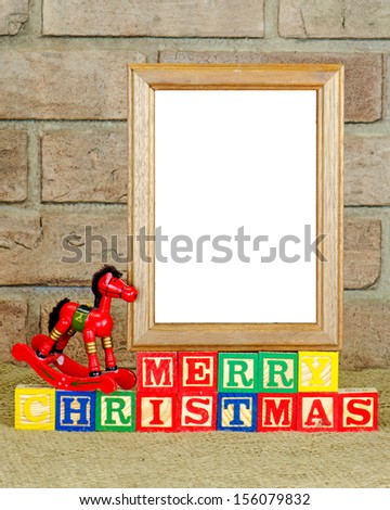 A frame with a blank panel on alphabet blocks spelling Merry Christmas
