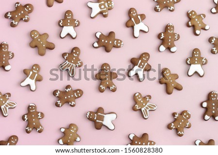 Gingerbread men on pastel pink background. Christmas, xmas, holiday, winter food concept. 