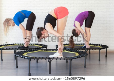 a group of girls engaged in gymnastics fitness trampolines in the gym . girls train make stretching body flexibility smile and good mood