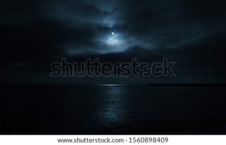 mystical picture the bright moon abive the black sea in the total darkness