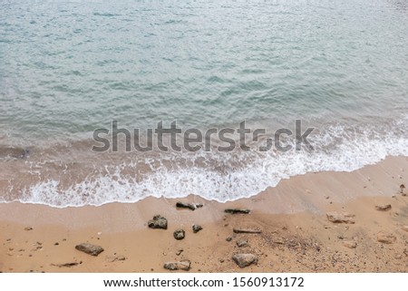 Top view of sea shore splashing at sandy beach. Horizontal color photography.