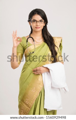 Pretty Indian young female doctor showing thumbs up.