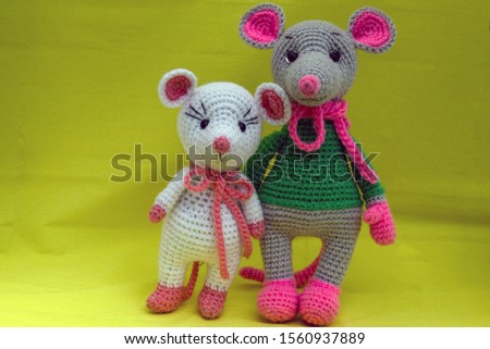 Amigurumi dolls posing for the photographer on a yellow background.