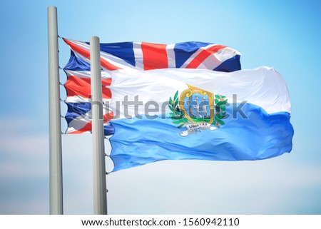 Flag of San Marino and Britain against the background of the blue sky