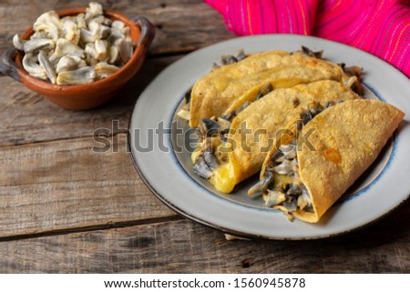 Traditional mexican corn smut quesadilla also called "huitlacoche" on wooden background