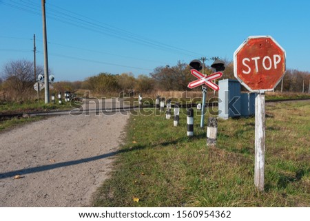 Non-regulated railway crossing in forest area with stop sign.