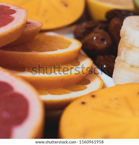 Tropical fruit mix and extra pitted dates on wooden table