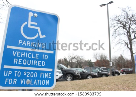 Handicap Parking Sign Vehicle ID Required up to $200 Fine For Violation Cars in Background Tree and Streetlight