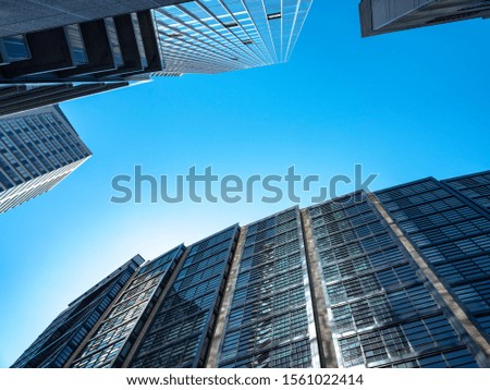 Blue sky looking up between two skyscrapers