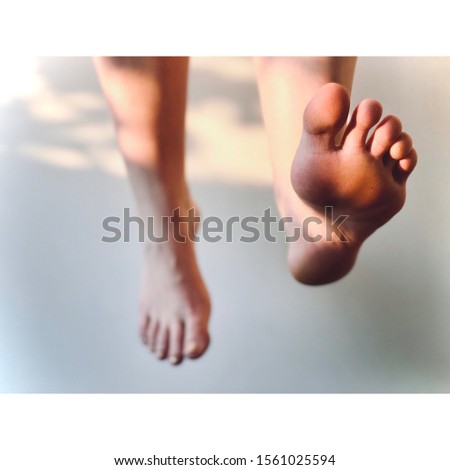 Relaxed legs hanging with foot extended Royalty-Free Stock Photo #1561025594