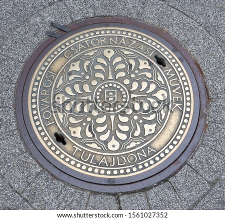 Ornate manhole cover downtown in Budapest, capital city of Hungary