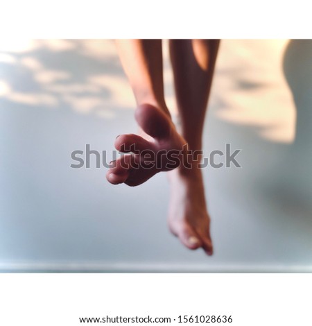 Hanging legs with one foot extending toes forwards Royalty-Free Stock Photo #1561028636