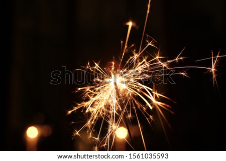 Burning and sparkling sparkler New Year festive bokeh background Royalty-Free Stock Photo #1561035593