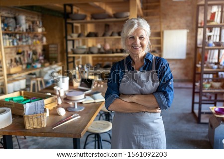 Portrait of senior female pottery artist in her art studio
