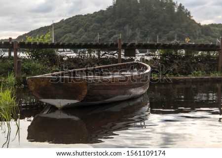 Small boat docked at Balmaha Boatyard Royalty-Free Stock Photo #1561109174