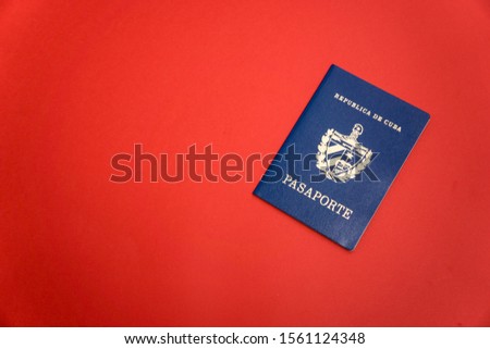 Official passport of Cuba on red background Royalty-Free Stock Photo #1561124348