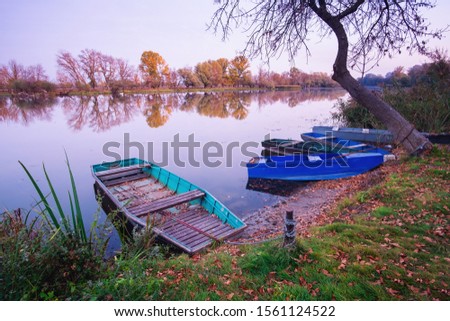 Old boat on the autumn pond in Tisza, Hungary
