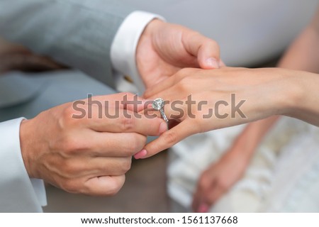 Wearing a ring at the engagement ceremony Royalty-Free Stock Photo #1561137668