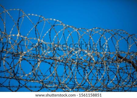 Barbed wire fence at the prison,fence with barbed wire and blue sky