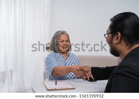 Business partners sit together shake hands sign of make a deal