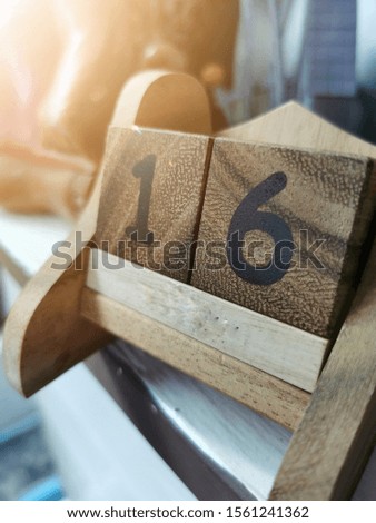 wooden calendar with light Ray. Number 16 