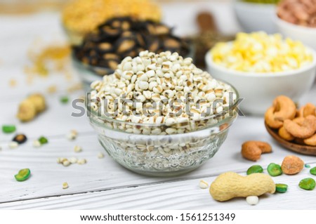 Adlay millet or pearl millet white Job's tears on bowl / Coix Lachrymal adlay jobi with different whole grains beans and legumes seeds background 