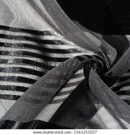 Background texture, pattern, collection, light transparent silk fabric with stripes in different sizes, black, exquisite luxury