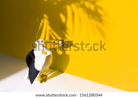 Figure of an animal on a yellow background. Shadow of the Pelican. Hot summer trend ecology.
