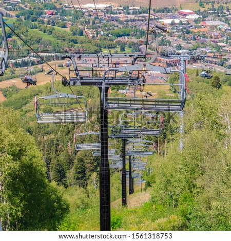 Square frame Chairlifts overlooking hiking trails and building on a summer day in Park City