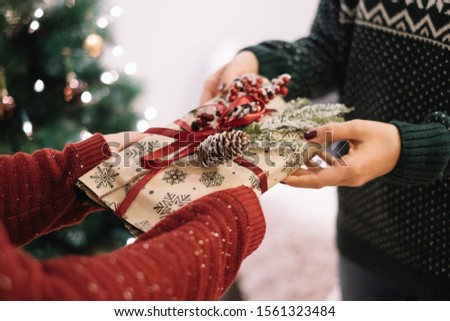Cropped image of gift exchange between woman and kid