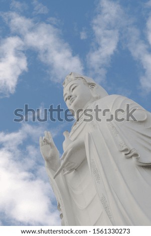 Lady Buddha against the cloudy sky in a Buddhist temple