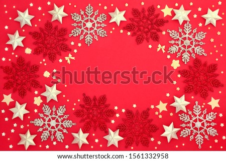 Christmas winter & new year background border with gold star & snowflake bauble decorations on red background with copy space. Traditional Christmas card for the holiday season. 