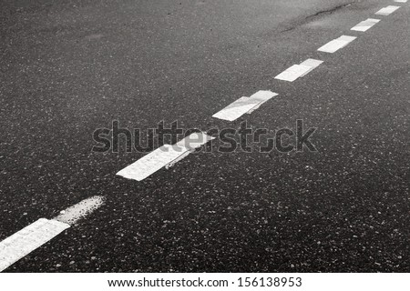 Dark wet asphalt road background with striped dividing marking line