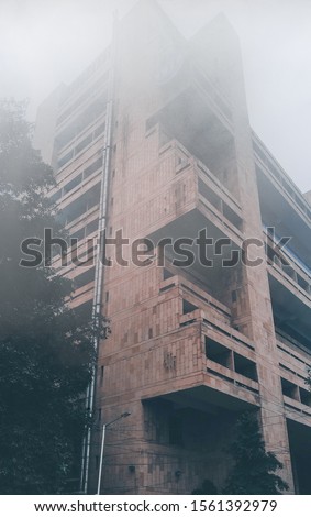 A high storey building with fog 