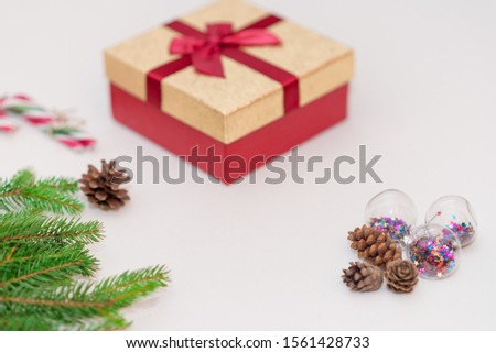 Christmas fir tree branches with gift box,cones and candy cane on white background.Top view.