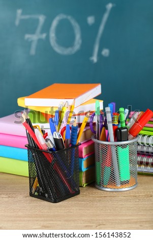 Office supplies on table on school board background 