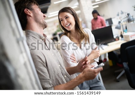 Cheerful coworkers in office during company meeting Royalty-Free Stock Photo #1561439149
