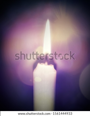 A digitally manipulated photograph of a burning candle with a colourful overlay & vignette border. 
