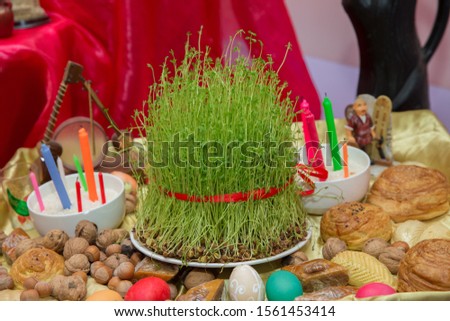 Traditional shekerbura, eggs ,  mutaki, shirinchorek, kata and pakhlava as Novruz symbol on xoncha on white background Azerbaijan holiday . Semeni . Candle . khoncha . In hell, hazelnuts, gooseberries