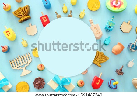 religion image of jewish holiday Hanukkah with menorah (traditional candelabra), spinning top over wooden blue background. top view, flat lay Royalty-Free Stock Photo #1561467340