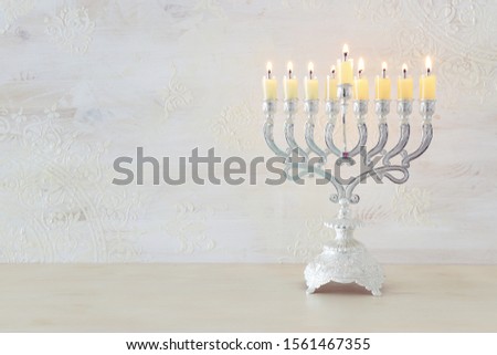 Religion image of jewish holiday Hanukkah with menorah (traditional candelabra) and oil candles over white background